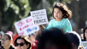 A 3-year-old girl makes her way toward the women's march in downtown Los Angeles with her family on Jan. 21, 2017. (Credit: Irfan Khan / Los Angeles Times)