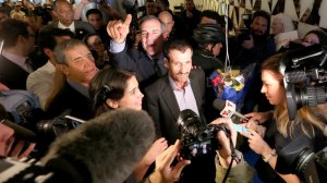 Ali Vayeghan, center, an Iranian citizen with a valid U.S. visa, is swarmed by the media as he is escorted through LAX by L.A. Mayor Eric Garcetti, after his arrival on Feb. 2, 2017. (Credit: Luis Sinco / Los Angeles Times)