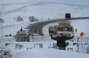 A native American activist confronts police guarding a bridge near Oceti Sakowin Camp on the edge of the Standing Rock Sioux Reservation on Nov. 30, 2016 outside Cannon Ball, North Dakota. (Credit: Scott Olson/Getty Images)