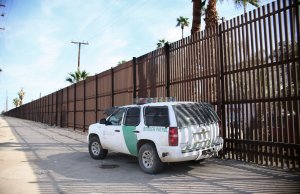 A Border Patrol agent looks over the US-Mexico border wall in Calexico, California, in the Imperial Valley, on Tuesday, January 31, 2017. (Credit: SANDY HUFFAKER/AFP/Getty Images)