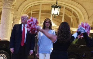 U.S. President Donald Trump and First Lady Melania Trump watch the Palm Beach Central High School marching band perform as it greets them upon arrival to watch the Super Bowl at Trump International Golf Club Palm Beach in Florida on Feb. 5, 2017. (Credit: Mandel Ngan / AFP / Getty Images)