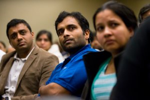 Alok Madasani, victim of the Austins Bar shooting, listens as Maggie Grillot, sister to shooting victim Ian Grillot, addresses a prayer vigil on Feb. 26, 2017, at the Ball Conference Center in Olathe, Kansas. (Credit: Kyle Rivas/Getty Images)