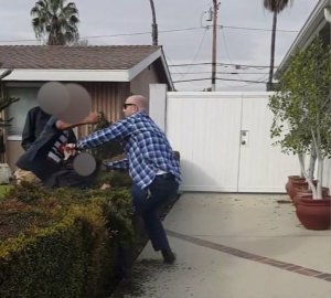 Cellphone video recorded by a witness shows a teen apparently striking at an off-duty LAPD officer as the officer holds onto another teen in the hedge on Feb. 22, 2017.
