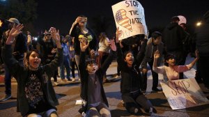 Demonstrators kneel in front of an Anaheim police formation to protest a confrontation between an off-duty LAPD officer and a group of teenagers. (Credit: Marcus Yam / L.A. Times)
