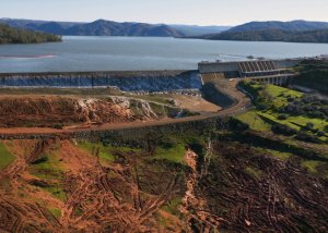 This aerial view from a California Department of Water Resources drone shows water flowing over the auxiliary spillway at Oroville Dam on Saturday, February 11, 2017, after the lake level exceeded 901 feet elevation above sea level. (Credit: Zack Cunningham / California Department of Water Resources)