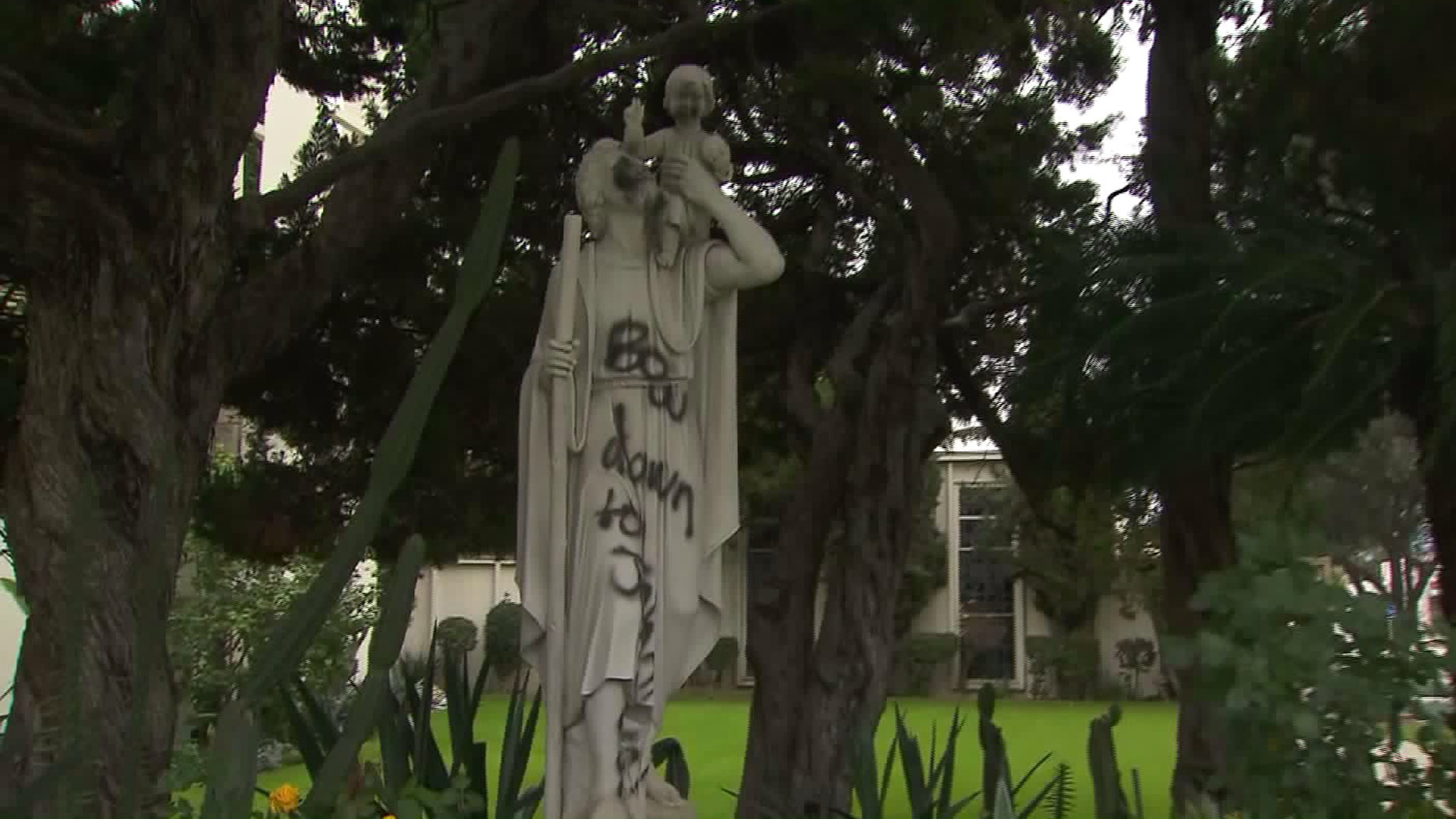 A vandal wrote "Bow down to Jehovah on three statues, one of which is seen on Feb. 27, 2017. (Credit: KTLA)
