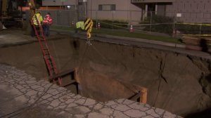 Crews on Feb. 20, 2017 continued to repair a sinkhole in Studio City where a woman fell in while driving her car days earlier. (Credit: KTLA)