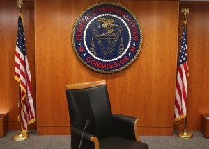 The seal of the Federal Communications Commission hangs behind the commissioner's chair inside the hearing room at the FCC headquarters Feb. 26, 2015, in Washington, D.C. (Credit: Mark Wilson/Getty Images)