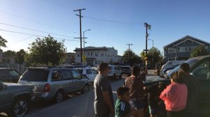 People gather at a South Los Angeles park, looking toward where a man opened fire at police on June 15, 2017. (Credit: Leila Miller / Los Angeles Times)