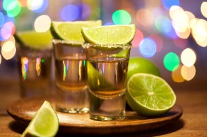 Gold tequila shots with lime fruits are seen in this file photo. (Credit: iStock / Getty Images Plus)