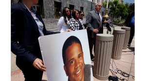 A poster showing the face of Dennis "Todd" Rogers, who was killed in a deputy-involved shooting in Ladera Heights in March, is held up at a press conference in Los Angeles. (Credit: Francine Orr / Los Angeles Times)