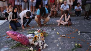 People pray and mourn at an informal memorial at the place where 32-year-old Heather Heyer was killed when a car plowed into a crowd of people protesting against the white supremacist Unite the Right rally Aug. 13, 2017, in Charlottesville, Virginia. (Credit: Chip Somodevilla/Getty Images)