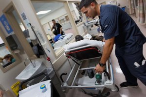 A paramedic moves a patient on his hospital bed at a Miami hospital on April 30, 2017. (Credit: Joe Raedle/Getty Images)