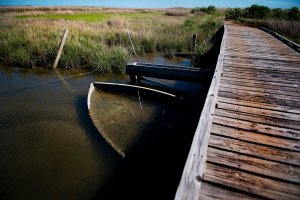 A submerged boat rests under a bridge in Tangier, Virginia, May 15, 2017, where climate change and rising sea levels threaten the inhabitants of the slowly sinking island. (Credit: Jim Watson / AFP / Getty Images)