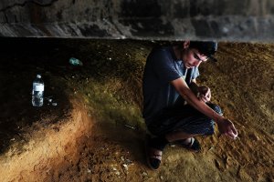 Mike, 22, a heroin addict who began using opiates when he was 13, pauses to shoot-up by a railway underpass in the Kensington section of Philadelphia, which has become a hub for heroin use, on July 31, 2017. (Credit: Spencer Platt / Getty Images)