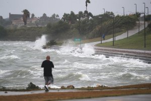 A man walks near the bay waters as they churn from approaching Hurricane Harvey on August 25, 2017 in Corpus Christi, Texas. (Credit: Joe Raedle/Getty Images)