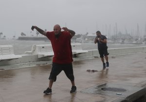 Raul Barral and Carlos Guerra (from left) walk through high wind and driving rain together before the arrival of Hurricane Harvey on Aug. 25, 2017, in Corpus Christi, Texas. (Credit: Joe Raedle / Getty Images)