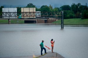 A couple looks at floodwater on Route 288 during the aftermath of Hurricane Harvey Aug. 27, 2017, in Houston, Texas. (Credit: Brendan Smialowski / AFP / Getty Images)