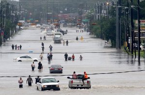 People walk through the flooded waters of Telephone Road in Houston on Aug. 27, 2017. (Credit: Thomas B. Shea / AFP / Getty Images)