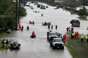 People make their way out of a flooded neighborhood after it was inundated with rain water following Hurricane Harvey on August 29, 2017 in Houston, Texas. (Credit: Scott Olson/Getty Images)