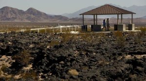 Visitors walk underneath one of the gazebos at the Amboy Crater off Route 66 in the Mojave Desert in 2012. (Credit: Mark Boster / Los Angeles Times)