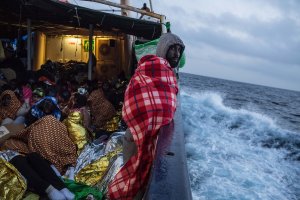 Refugees and migrants are seen on deck of the Spanish NGO Proactiva Open Arms rescue vessel Golfo Azzurro sailing towards the Italian port of Pozzallo after being rescued off Libyan coast north of Sabratha, Libya, on Feb. 19, 2017. (Credit: David Ramos / Getty Images)