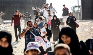 Syrian refugees arrive at a border crossing gate in south-central Turkey to cross to Syria for the Eid al-Adha Muslim holiday on Aug. 28, 2017. (Credit: Bulent Kilic / AFP / Getty Images)
