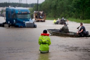 People make their way through a flooded street during the aftermath of Hurricane Harvey on Aug. 29, 2017, in Houston, Texas. (Credit: Brendan Smialowski / AFP / Getty Images)