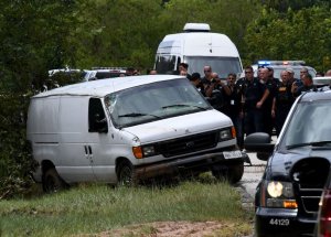 Police investigators watch as the van containing the six members of the the Saldivar family who died is towed to the road after they crashed their van into Greens Bayou as they tried to flee Hurricane Harvey during heavy flooding in Houston, Texas on August 30, 2017. / AFP PHOTO / MARK RALSTON (Photo credit should read MARK RALSTON/AFP/Getty Images)