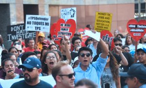 Young immigrants and supporters walk holding signs during a rally in support of Deferred Action for Childhood Arrivals (DACA) in Los Angeles on September 1, 2017.