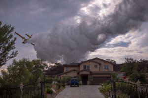 A Super Scooper CL-415 firefighting aircraft from Canada makes a drop to protect a house during the La Tuna Fire on Sept. 3, 2017, near Burbank. (Credit: David McNew / Getty Images)