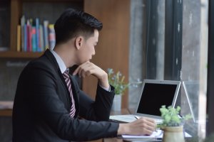 A young business man is seen sitting at his desk in this file photo. (Credit: iStock / Getty Images Plus)