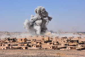 Smoke rises from buildings on the northern outskirts of Deir Ezzor on Sept. 13, 2017, as Syrian forces advance during their ongoing battle against the Islamic State group. (Credit: George Ourfalian / AFP / Getty Images)