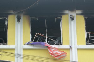 Malaysian national flag flutters outside burnt windows of the Darul Quran Ittifaqiyah religious school in Kuala Lumpur on Sept. 14, 2017. (Credit: Sadiq Asyraf / AFP / Getty Images)