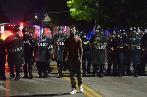 A lone protester is seen as law enforcement officers advance behind him during a protest following a not guilty verdict on Sept. 15, 2017, in St. Louis, Missouri. (Credit: Michael B. Thomas / Getty Images)