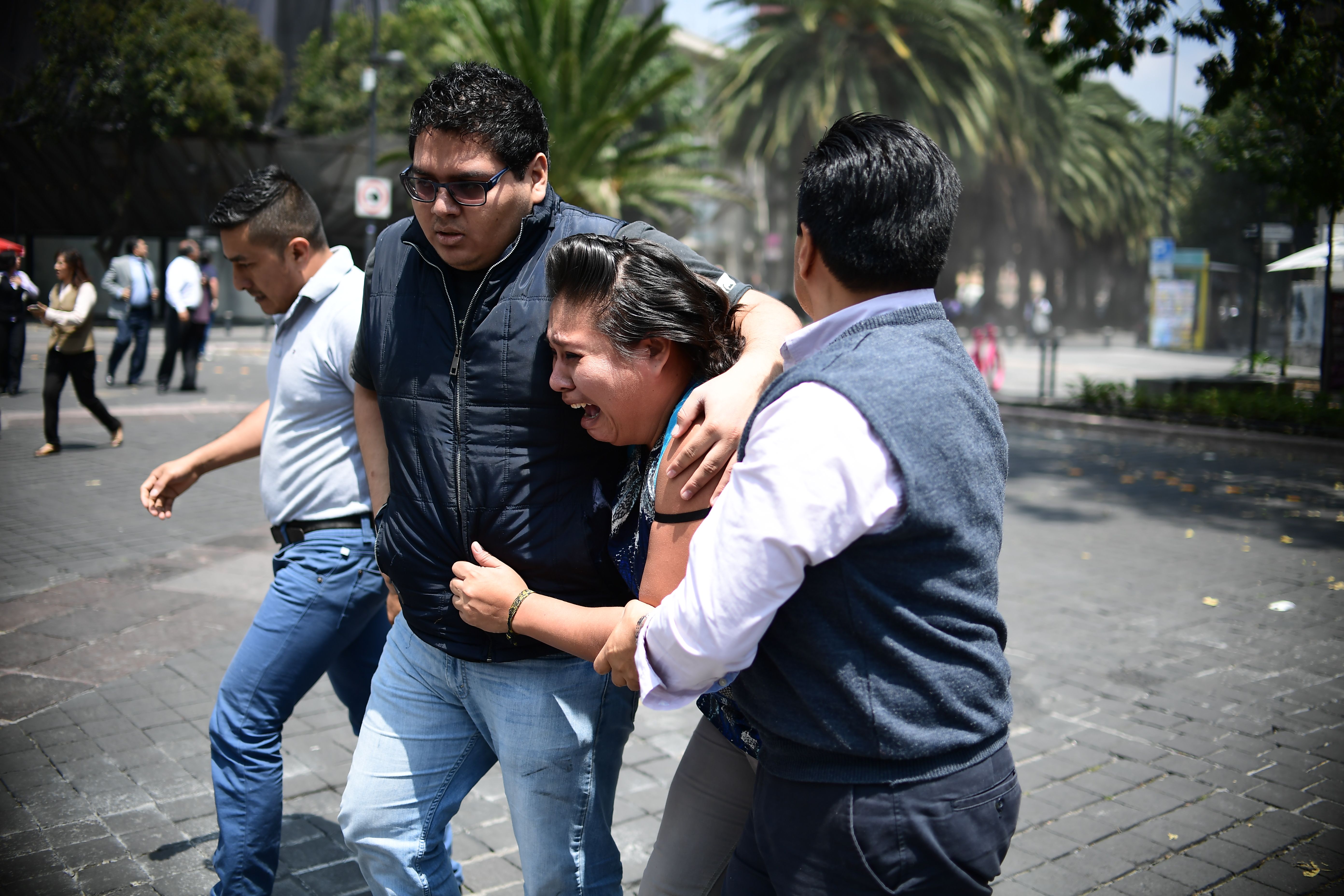 People react as a real quake rattles Mexico City on Sept. 19, 2017, as an earthquake drill was being held in the capital. (Credit: RONALDO SCHEMIDT/AFP/Getty Images)