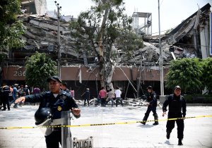 Police officers cordon the area off after a building collapsed during a quake in Mexico City on Sept. 19, 2017. The powerful earthquake shook Mexico City on on the 32nd anniversary of a devastating 1985 quake. (Credit: RONALDO SCHEMIDT/AFP/Getty Images)