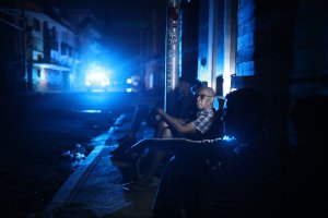Jaime Degraff sits outside as he tries to stay cool with people waiting for the damaged electrical grid to be fixed after Hurricane Maria passed through the area on Sept. 23, 2017, in San Juan, Puerto Rico. (Credit: Joe Raedle / Getty Images)
