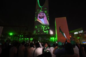 People watch a projection depicting a portrait of Crown Prince Mohammed bin Salman during an event in the capital Riyadh on late Sept. 23, 2017. (Credit: AFP/Getty Images)