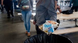 A new law will allow schools to collect unopened food items and untouched fruit for donation to food banks. In this photo from 2014, students from Washington Preparatory High are throwing away unused milk cartons, part of millions of dollars in wasted food. (Credit: Gina Ferazzi / Los Angeles Times)