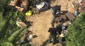 Los Angeles County Sheriff's Officials look through a Lawndale back yard where a cache of weapons was found on Sept. 29, 2017. (Credit: KTLA)