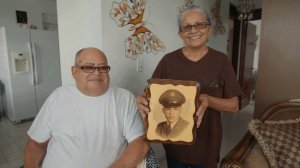 Miguel Olivera and his wife Diana Aponte show a picture from his time in service. (Credit: CNN)
