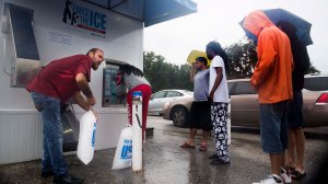 A volunteer helps other residents get ice from a vending machine in Tampa, Florida, on Sept. 10, 2017. (Credit: Jim Watson/AFP/Getty Images)