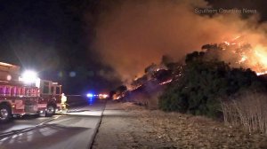 Firefighters battle a blaze near the 57 Freeway in Diamond Bar on Oct. 18, 2017. (Credit: Southern Counties News)