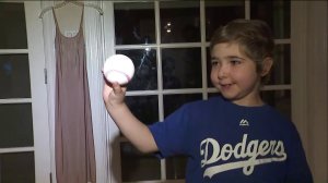 Elysa Shapiro shows off the ball she threw to Joc Pederson at Dodger Stadium on July 30, 2017. (Credit: KTLA)