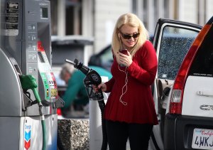 A woman prepares to pump gasoline into her vehicle at a Chevron gas station on Feb. 9, 2015, in San Rafael. (Credit: Justin Sullivan / Getty Images)