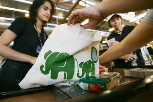Cashier Bianca Kurian, left, hands out free reusable grocery bags at a Whole Foods in Pasadena on April 22, 2008. (Credit: David McNew / Getty Images)
