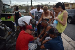 People take water from tanks in a truck in Juventud neighborhood , in Toa Alta, Puerto Rico, on October 1, 2017. (Credit: HECTOR RETAMAL/AFP/Getty Images)