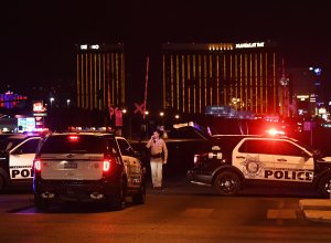 Police form a perimeter around the road leading to the Mandalay Hotel (background) after a gunman killed at least 50 people and wounded more than 200 others when he opened fire on a country music concert in Las Vegas on Oct. 2, 2017. (Credit: MARK RALSTON/AFP/Getty Images)