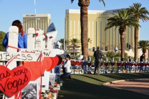A woman prays beside 58 white crosses for the victims of Sunday night's mass shooting, on Las Vegas Strip just south of the Mandalay Bay hotel, Oct. 6, 2017, in Las Vegas, Nevada. (Credit: Robyn Beck / AFP / Getty Images)